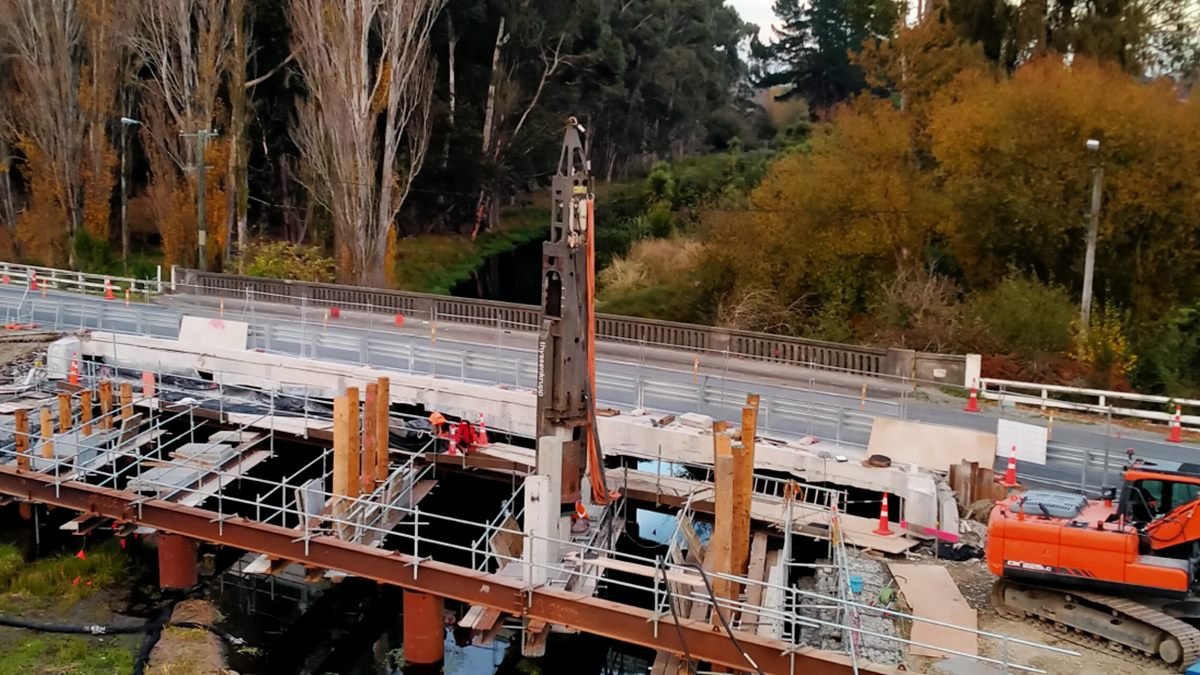 Bridge replacement works over a river, with a piling rig, scaffolding and steel temporary works