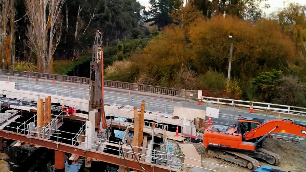 Bridge replacement works over a river, with a piling rig, scaffolding and steel temporary works