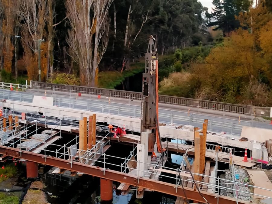 Bridge replacement works over a river, with a piling rig, scaffolding and steel temporary works